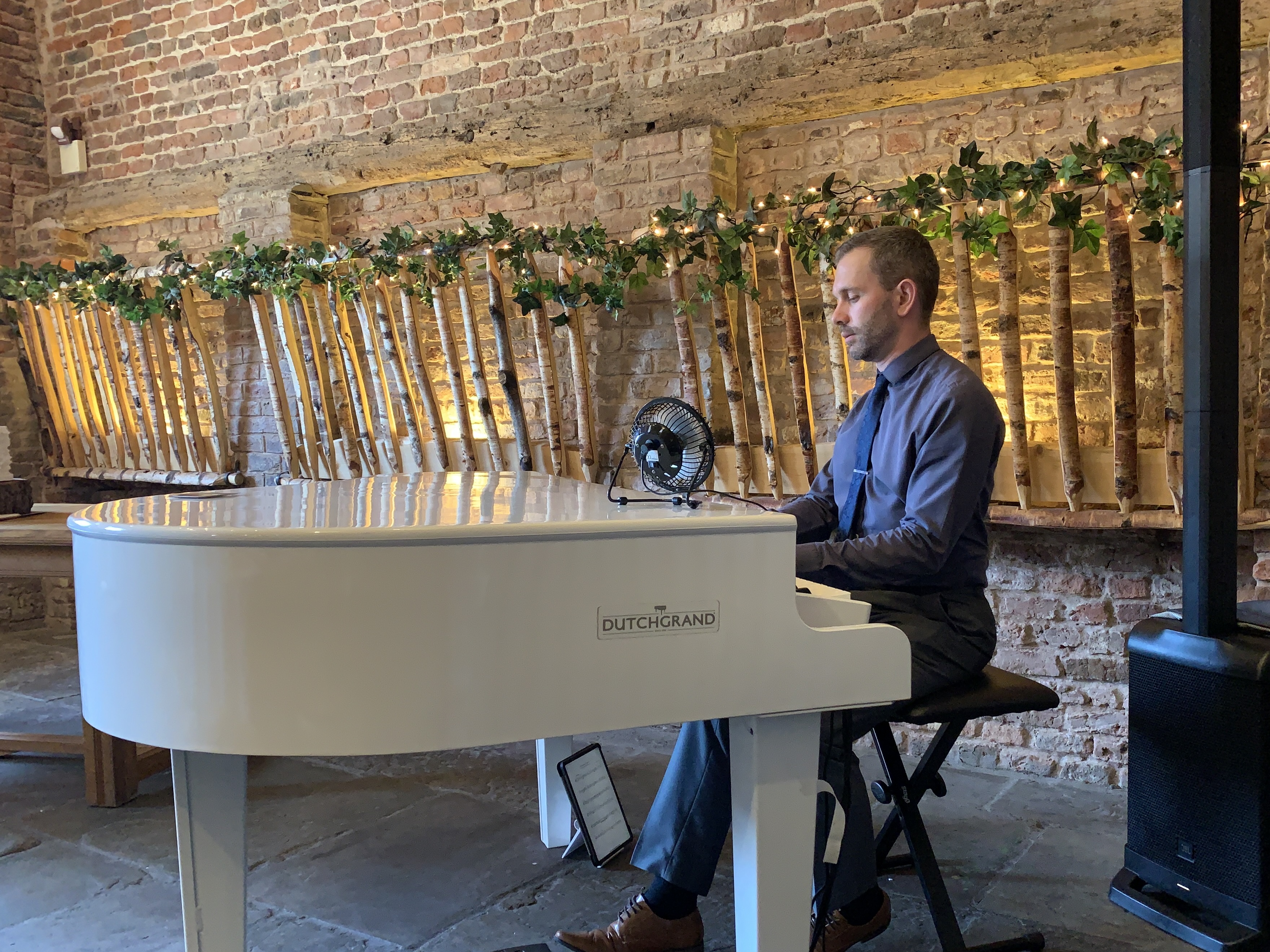 Meols Hall wedding pianist Craig Smith plays his white baby grand piano during a wedding breakfast in The Tithebarn