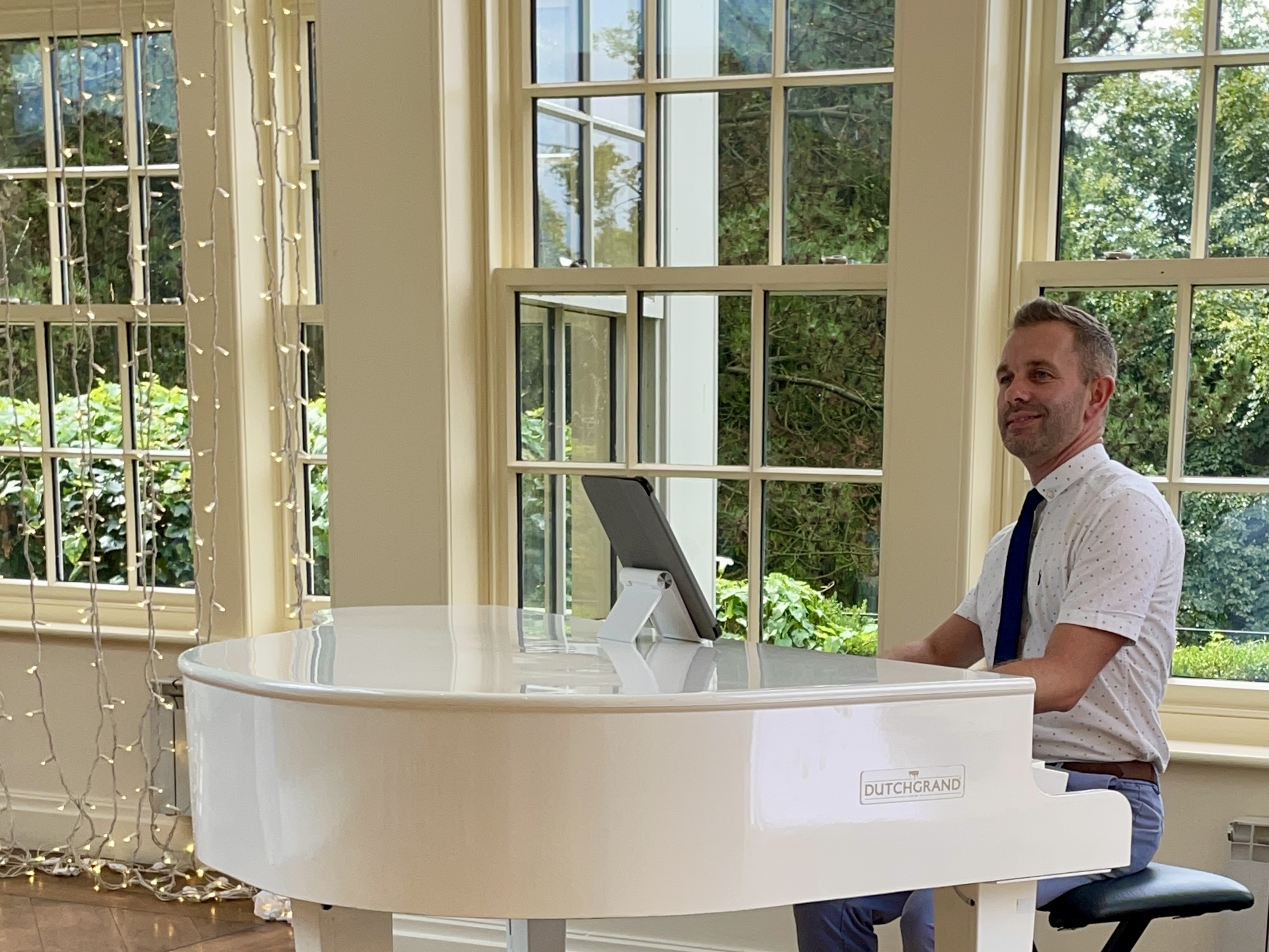 Mitton Hall wedding pianist Craig Smith at his white piano in the orangery