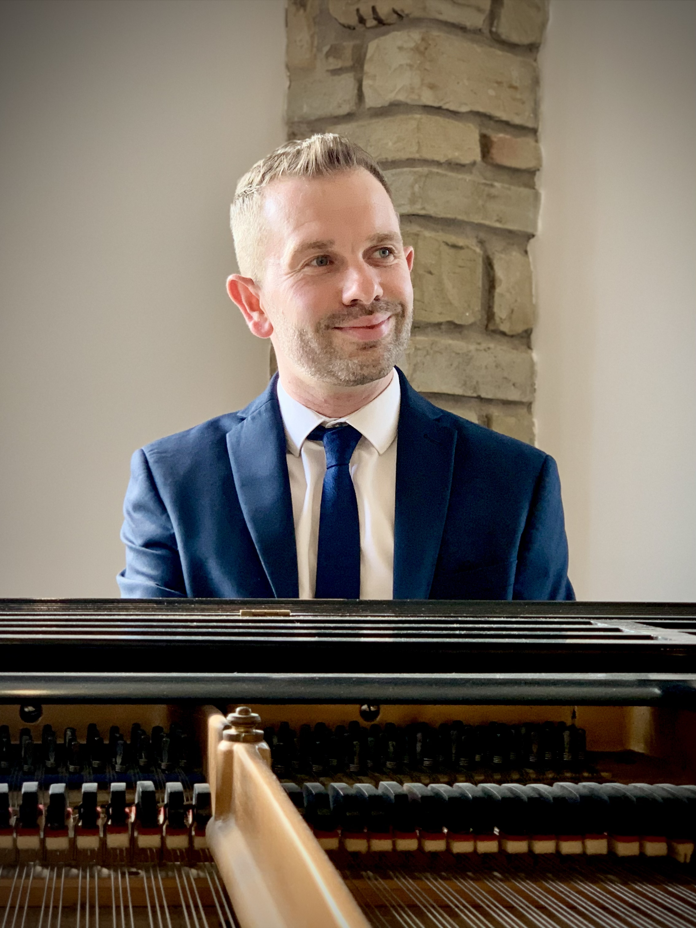 Mytton Fold wedding pianist Craig Smith smiles from the grand piano