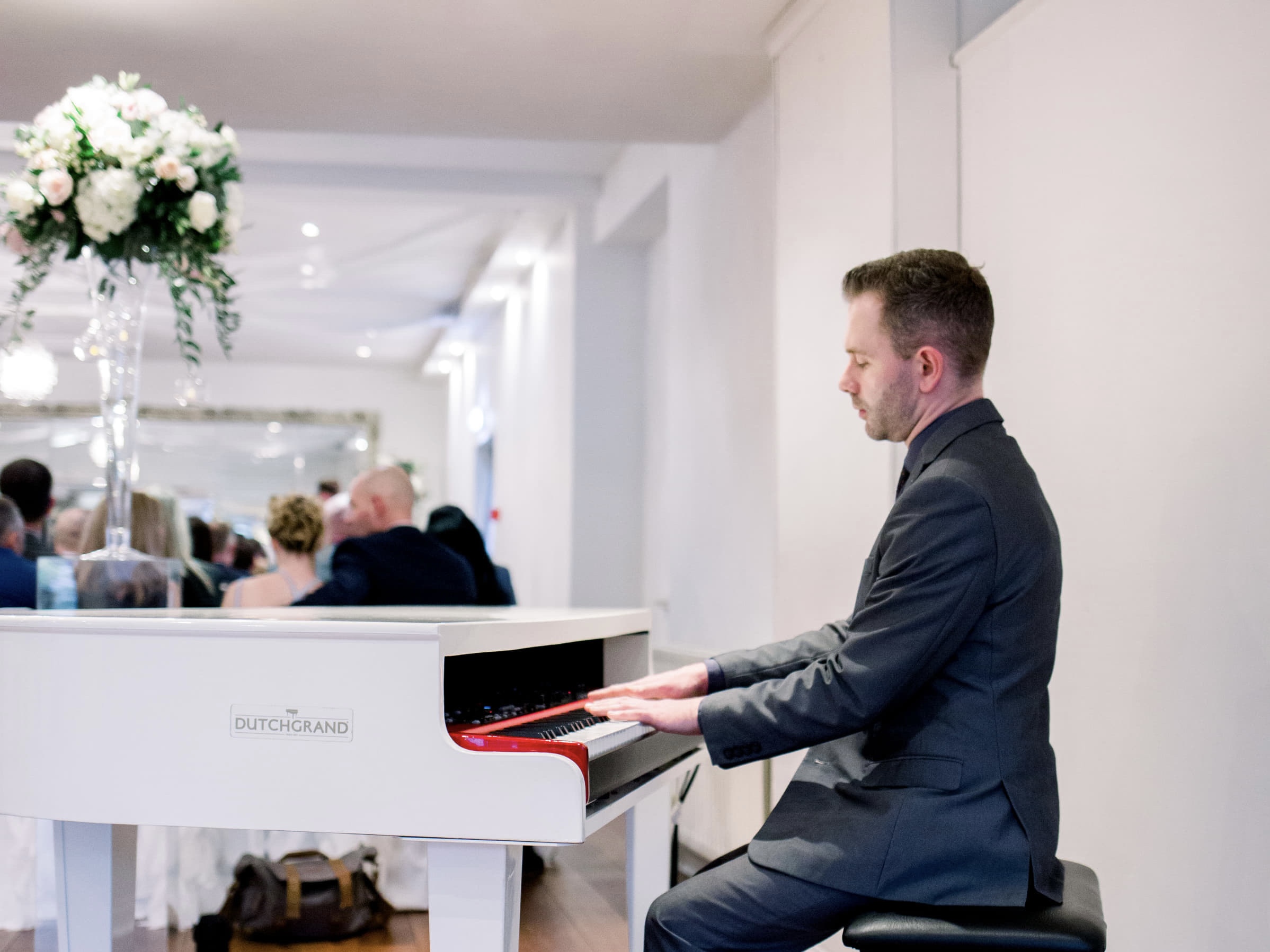 Wedding pianist Craig Smith plays his white piano during a Sparth House wedding ceremony