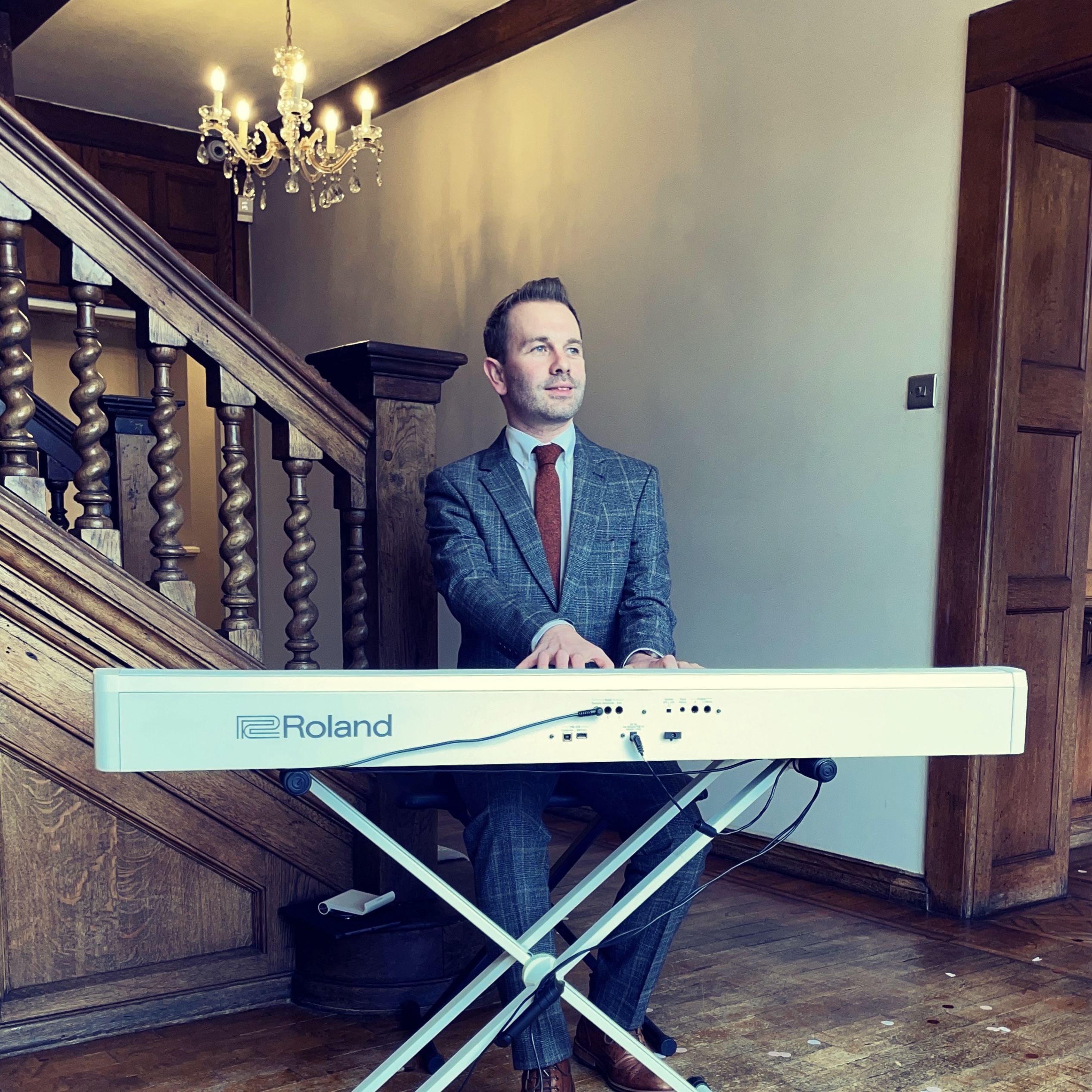 Wedding pianist Craig Smith plays piano to greet guests arriving to a Wrenbury Hall wedding